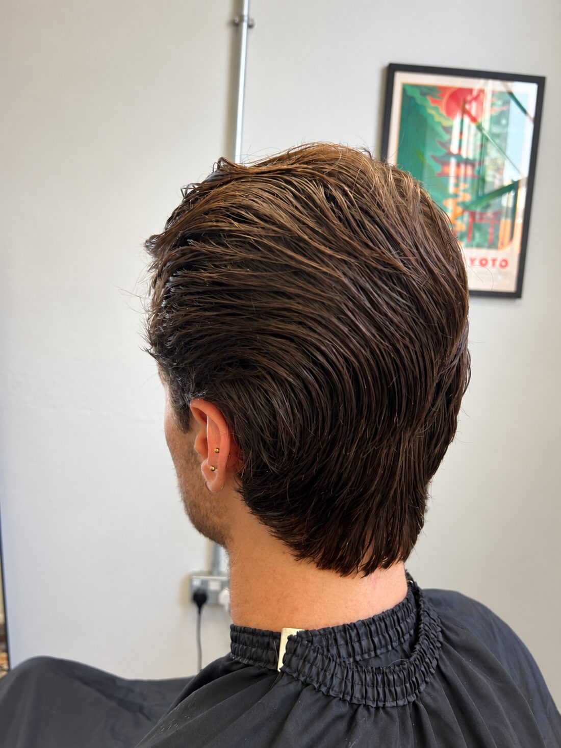 Swept-back longer cut with a tapered neckline, seen from behind