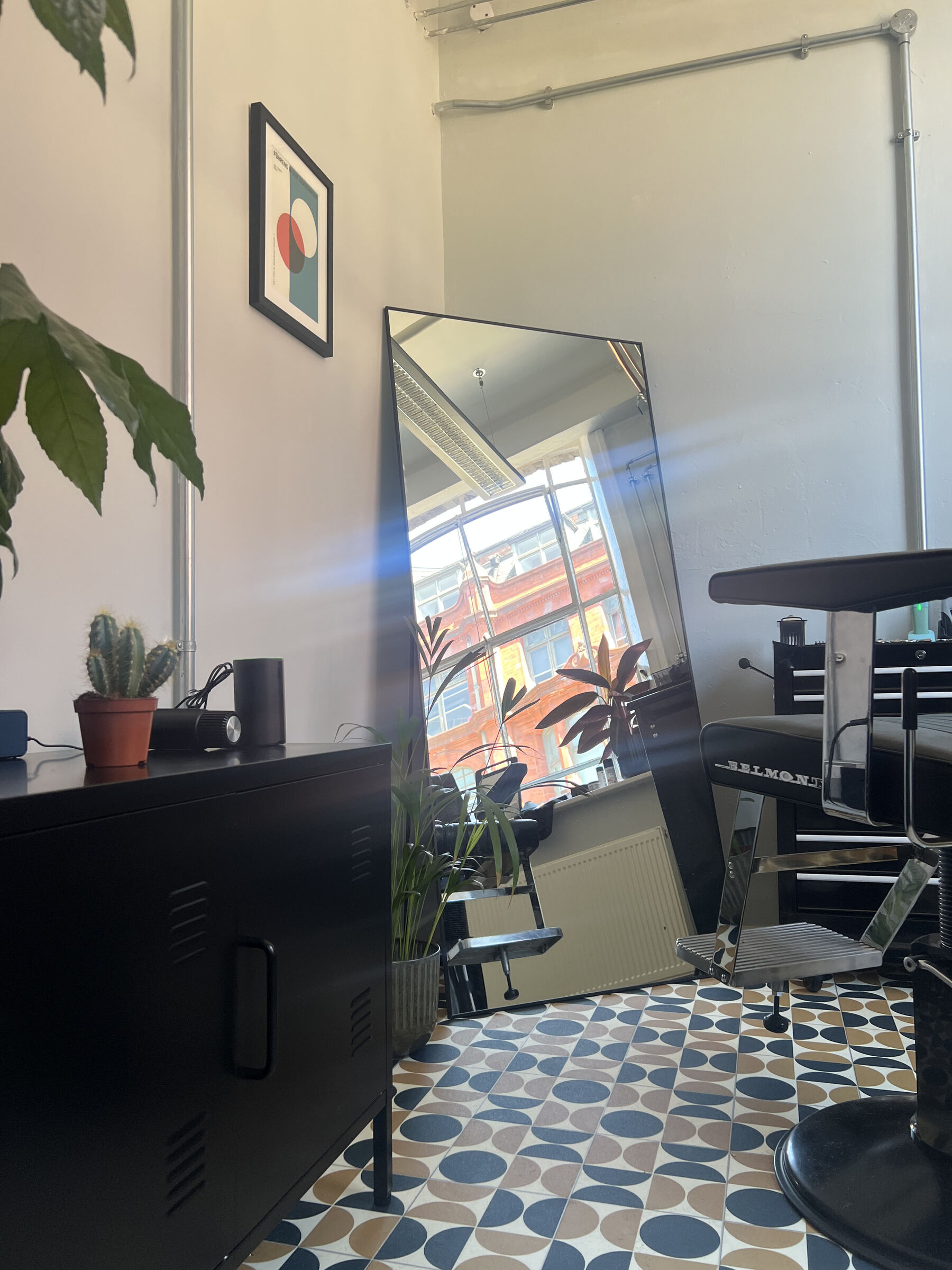 The black Belmont barber chair and tall mirror in the FORME studio